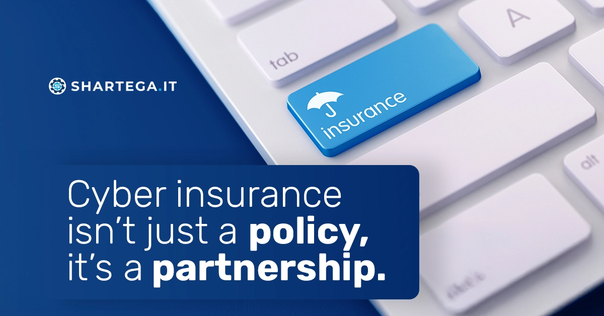 Keyboard with a blue key labeled "insurance" and the Shartega IT logo, representing cyber insurance and business protection.